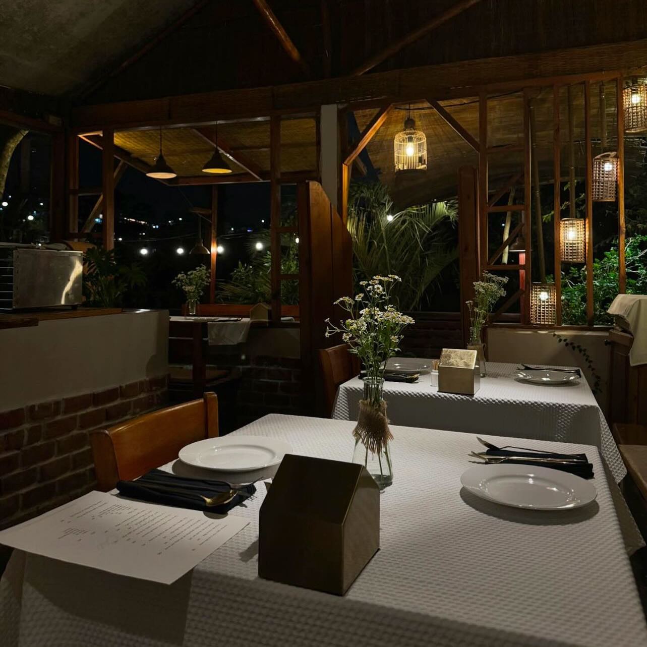 Two women sitting at a modern table talking with a city view behind them.
